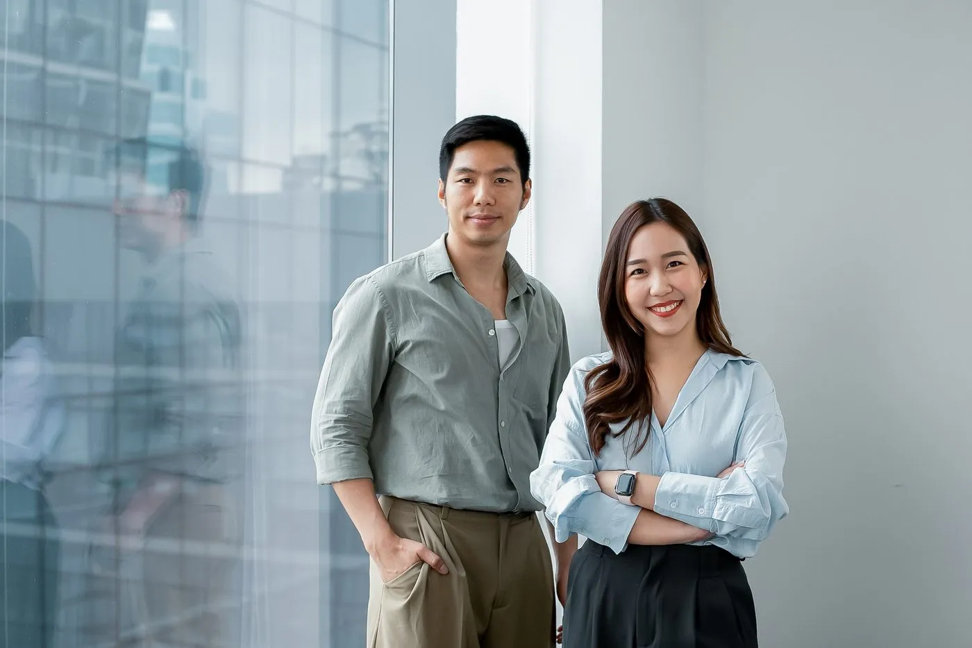 เพื่อนร่วมงาน Primal 2 คนดูหน้าจอแล็ปท็อปด้วยกันที่โต๊ะทำงาน