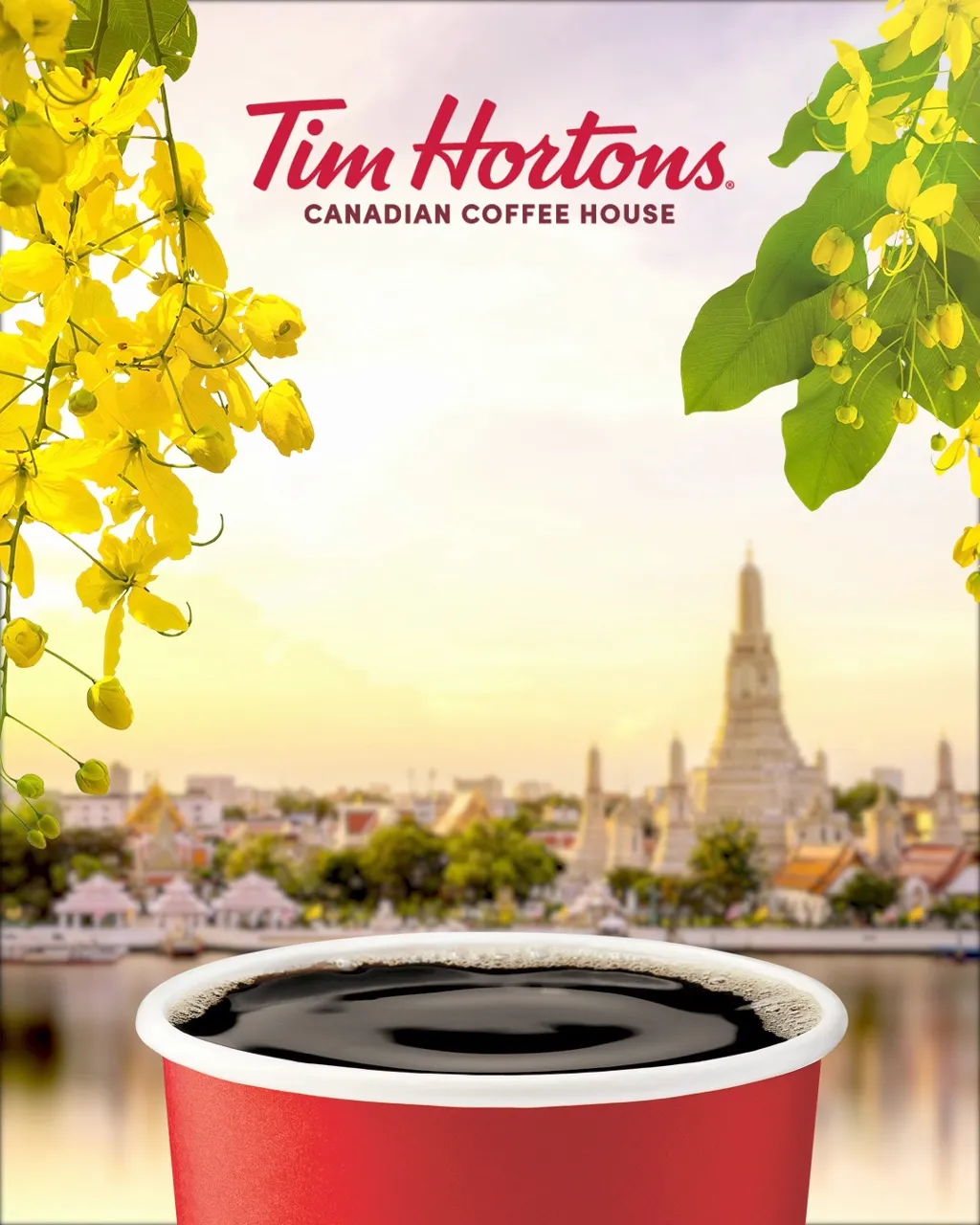 แก้วกาแฟดำสีแดงของ Tim Hortons โดยฉากหลังเปลี่ยนจากเมืองโทรอนโตกับใบเมเปิล เป็นวัดอรุณในกรุงเทพฯ กับดอกไม้สีเหลือง