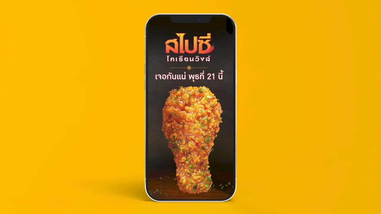 วิดีโอบนหน้าจอโทรศัพท์ เป็นปีกไก่ทอดกรอบเคลือบซอสสีแดง 1 ชิ้นบนพื้นหลังสีดำ ใต้ชื่อเมนูสไปซี่ โคเรียนวิงส์และวันเปิดตัว