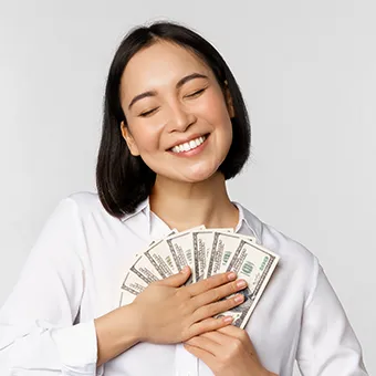 ผู้หญิงหลับตายิ้ม กอดธนบัตรที่คลี่เป็นรูปพัดไว้แนบอก