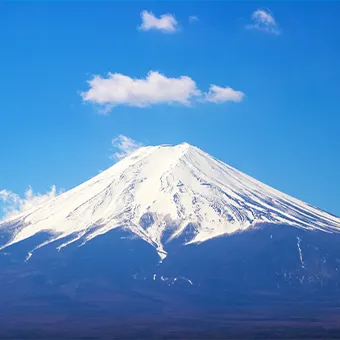 Snow-covered Mount Fuji under a blue sky with a few white clouds