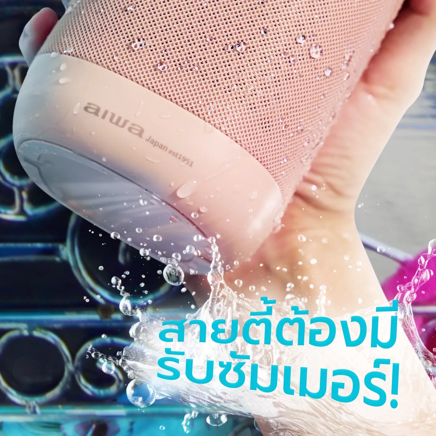 A hand holding a pink AIWA speaker in a splash of water, with a Thai headline in blue letters