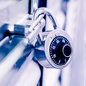 A combination padlock locked onto a metal latch