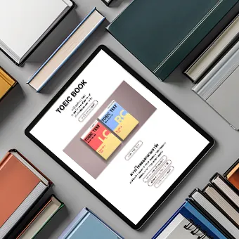 A tablet among closed hardback books, its screen showing a web page headed TOEIC BOOK with 2 TOEIC test book covers