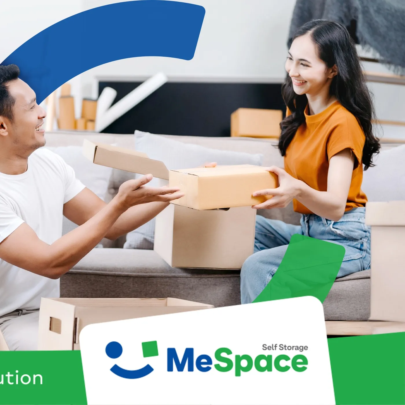 A man and a woman passing a cardboard box to each other on a sofa, with the MeSpace logo below them