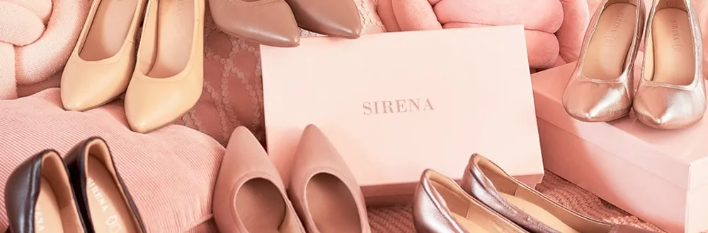 Pairs of beige, pink, brown and metallic pointed shoes around a pale pink SIRENA shoe box on pink cushions