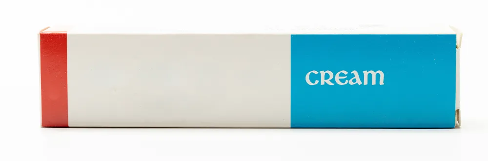 กล่องสีขาว แดง และฟ้า วางตะแคงบนพื้นสีขาว มีคำว่า Cream พิมพ์อยู่บนด้านสีฟ้า